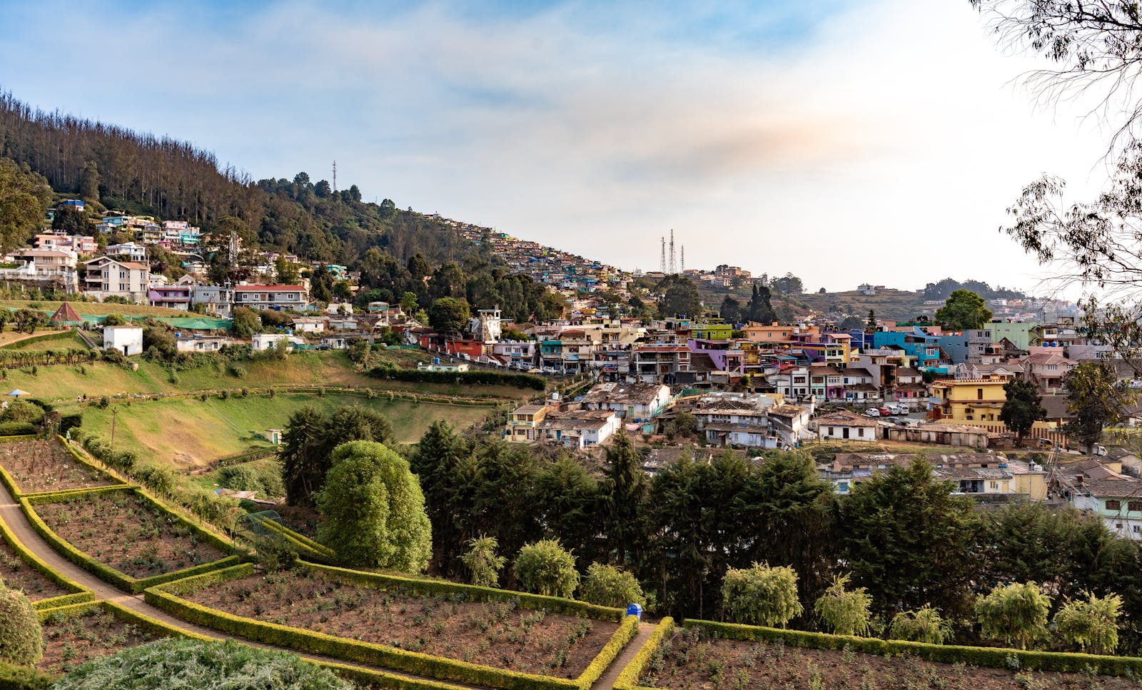 Charming view of Ooty town nestled in lush hills under a clear sky.